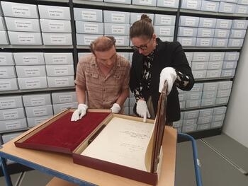 Bild vergr&ouml;&szlig;ern: Archivarin Jennifer Kr�ger und Archivar Robin Butte werfen einen Blick in das Goldene Buch der Stadt Herford
